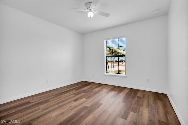 empty room featuring ceiling fan, baseboards, and wood finished floors