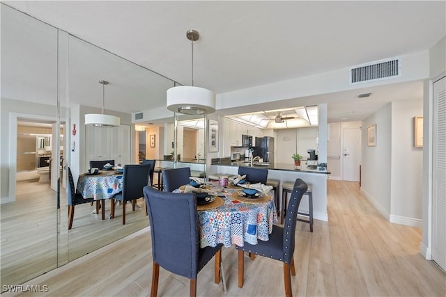 260 Seaview Ct Unit 402, Marco Island, FL 34145 - dining area with baseboards, light wood finished floors, and visible vents