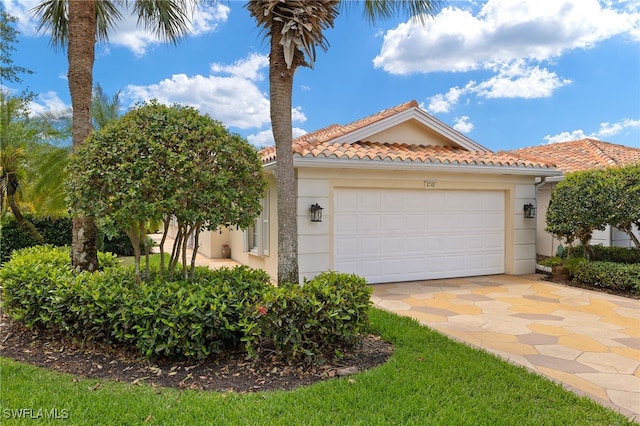 4748 San Carlo Ct, Naples, FL 34109 - mediterranean / spanish-style home featuring driveway, stucco siding, a tile roof, and an attached garage