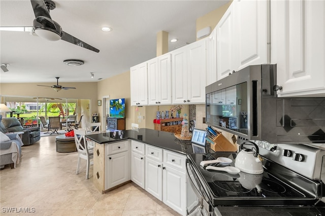 4748 San Carlo Ct, Naples, FL 34109 - kitchen with open floor plan, a peninsula, electric stove, and white cabinets