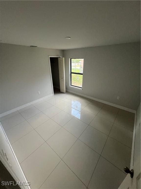 spare room featuring baseboards and light tile patterned floors