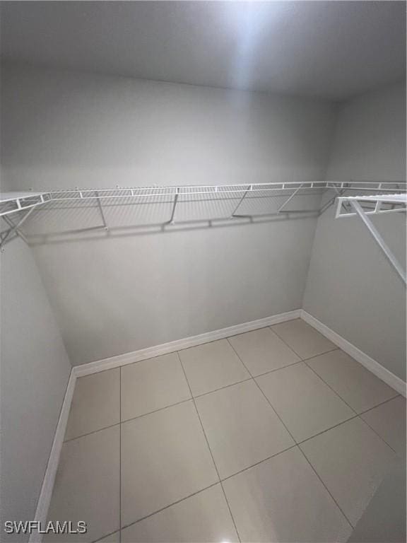 spacious closet with light tile patterned floors