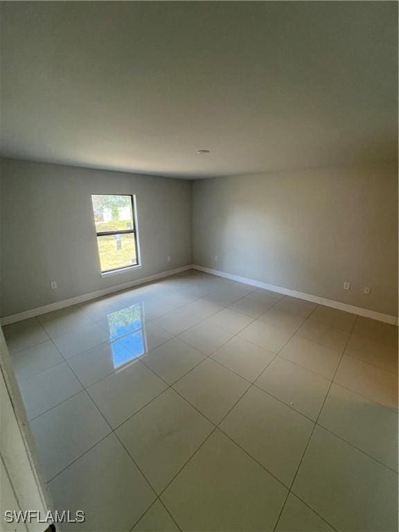unfurnished room with baseboards and light tile patterned floors