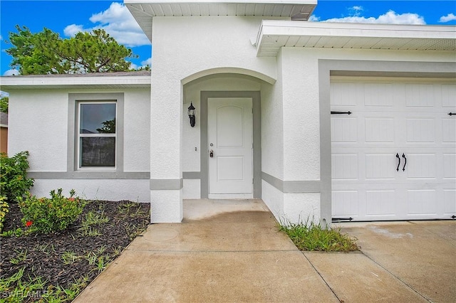 1821 SW 25th St, Cape Coral, FL 33914 - property entrance with a garage and stucco siding