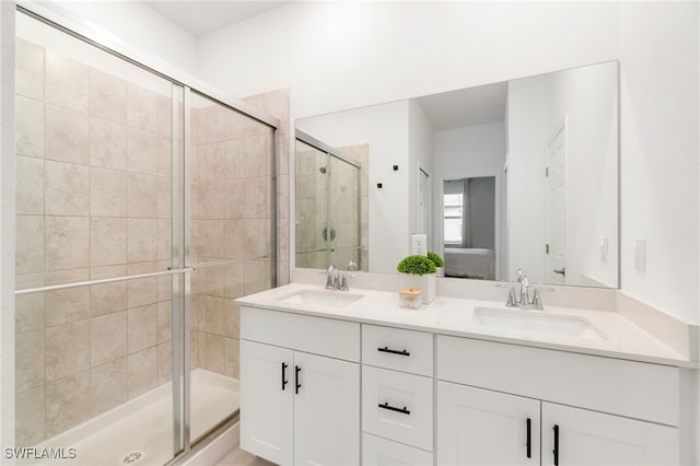 full bath featuring double vanity, ensuite bathroom, a stall shower, and a sink