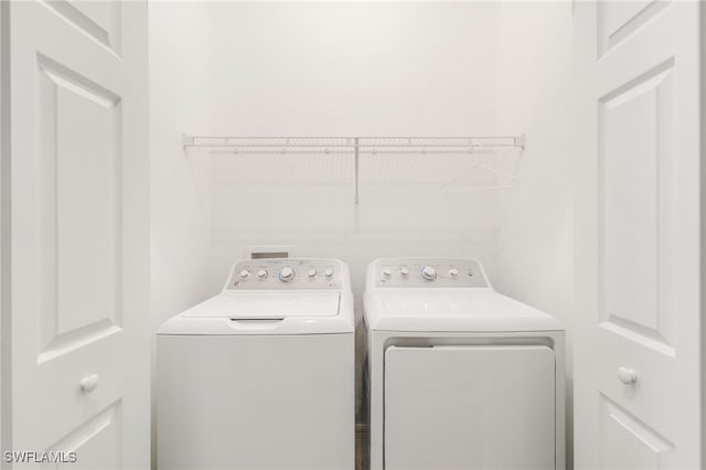 clothes washing area featuring washing machine and clothes dryer and laundry area