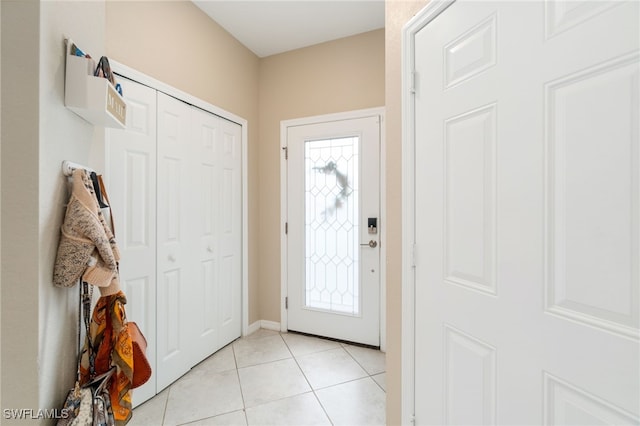foyer with light tile patterned floors and baseboards
