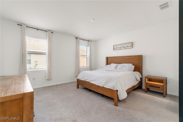 bedroom featuring light colored carpet, visible vents, and baseboards