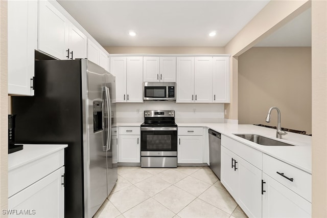 kitchen featuring a sink, light countertops, light tile patterned floors, white cabinets, and appliances with stainless steel finishes