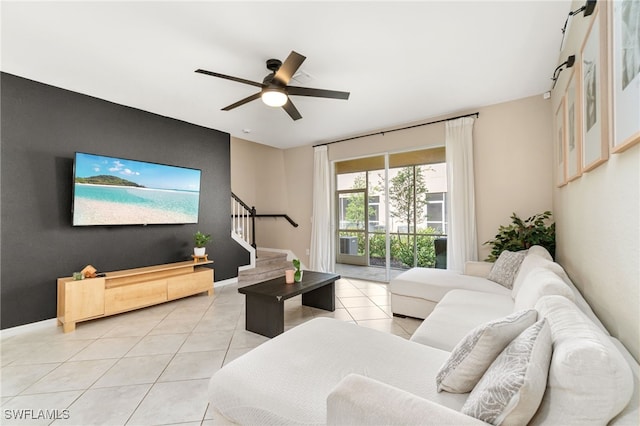 living room with a ceiling fan, light tile patterned flooring, and stairs