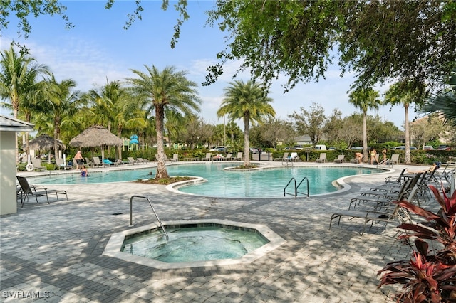 pool featuring a hot tub and a patio