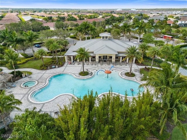 community pool with a patio area and a hot tub