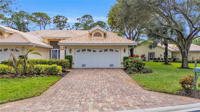 view of front of home featuring a tile roof, a front yard, a garage, decorative driveway, and stucco siding