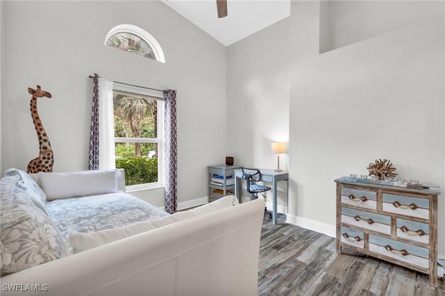 bedroom featuring baseboards, a ceiling fan, high vaulted ceiling, and wood finished floors