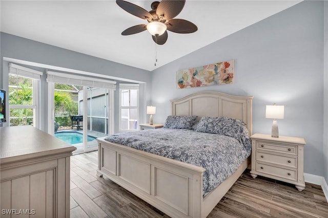 bedroom with multiple windows, access to exterior, wood finished floors, and lofted ceiling