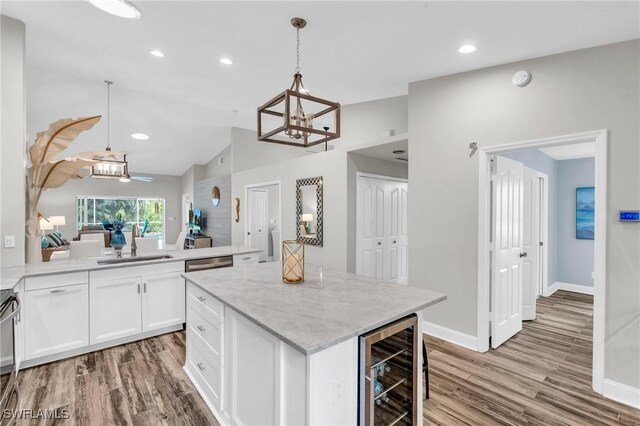 kitchen with wine cooler, a sink, wood finished floors, and a chandelier