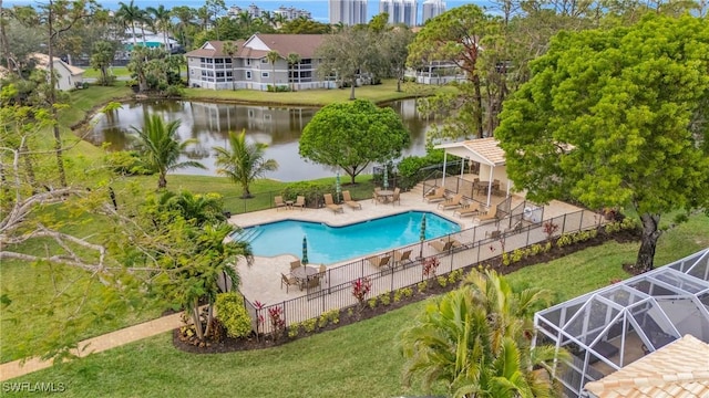 community pool with a yard, a water view, fence, and a patio