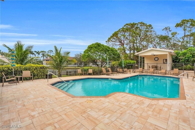 community pool with fence and a patio