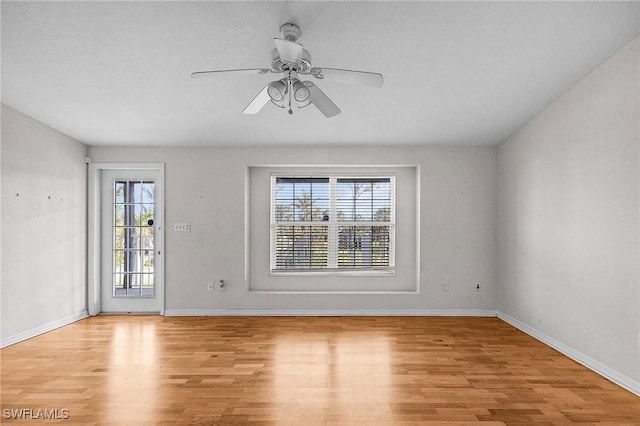 spare room with light wood-style floors, ceiling fan, and baseboards
