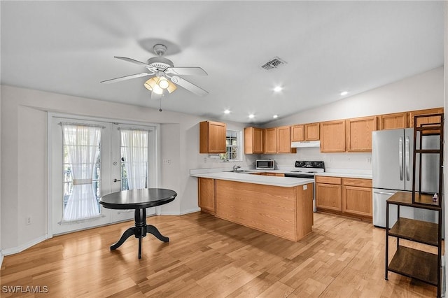 kitchen with stainless steel appliances, under cabinet range hood, light countertops, a peninsula, and vaulted ceiling