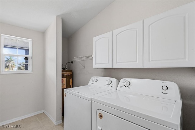 laundry area featuring washer and dryer, cabinet space, baseboards, and light tile patterned floors