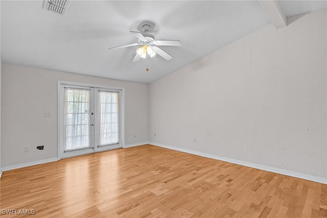 spare room featuring light wood-type flooring, ceiling fan, baseboards, and vaulted ceiling