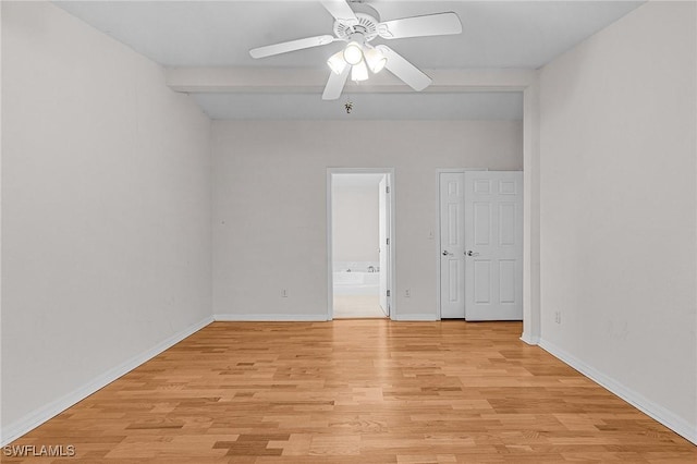 spare room featuring ceiling fan, light wood-style flooring, and baseboards