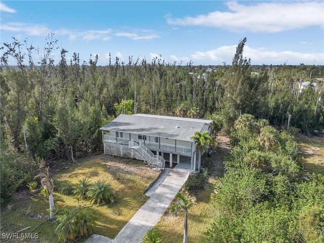 aerial view of property and surrounding area featuring a forest