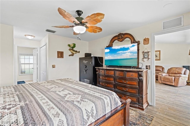 bedroom featuring ceiling fan, visible vents, and light wood-style floors