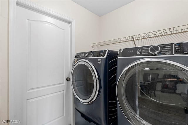 clothes washing area featuring separate washer and dryer and laundry area
