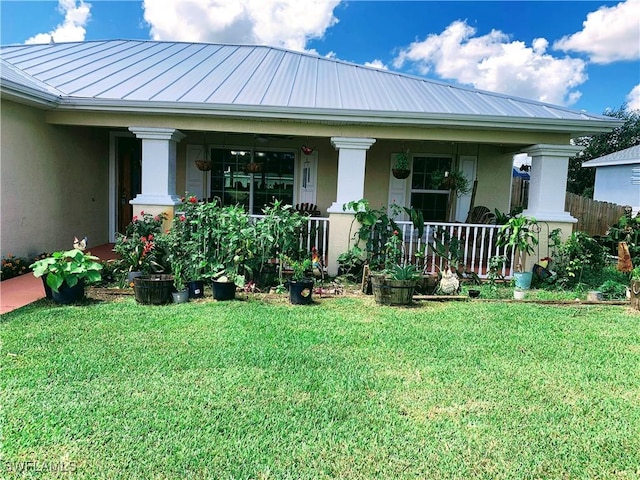 3303 32nd St SW, Lehigh Acres, FL 33976 - rear view of house with a porch, stucco siding, a yard, and a standing seam roof