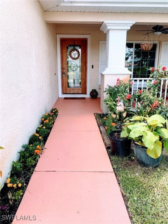 3303 32nd St SW, Lehigh Acres, FL 33976 - view of exterior entry featuring stucco siding, covered porch, and a ceiling fan