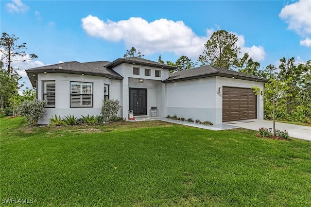 prairie-style home featuring concrete driveway, an attached garage, a front yard, and stucco siding