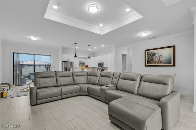 living room with crown molding, recessed lighting, and a raised ceiling