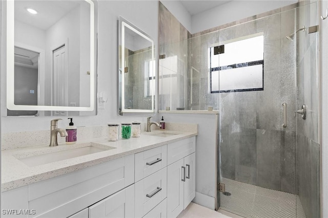 bathroom featuring double vanity, a sink, and a shower stall