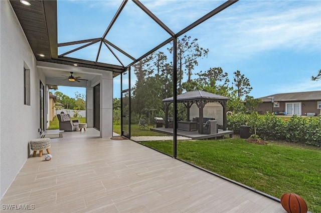 view of patio with a gazebo, a ceiling fan, glass enclosure, and an outdoor hangout area