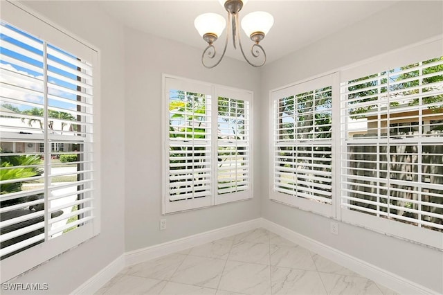 2524 Sailors Way Unit 118, Naples, FL 34109 - interior space with plenty of natural light, marble finish floor, baseboards, and a notable chandelier