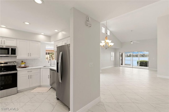 2524 Sailors Way Unit 118, Naples, FL 34109 - kitchen with a chandelier, baseboards, marble finish floor, open floor plan, and stainless steel appliances
