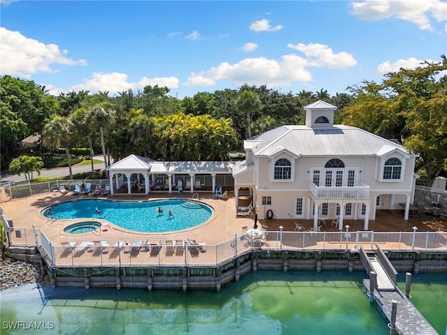 2524 Sailors Way Unit 118, Naples, FL 34109 - back of property featuring a community hot tub, fence, a community pool, a patio area, and metal roof