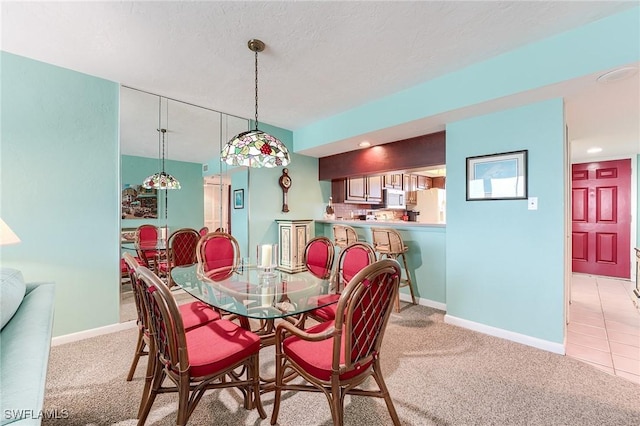 dining area with baseboards and light colored carpet