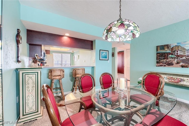 dining area with baseboards, carpet flooring, and a textured ceiling
