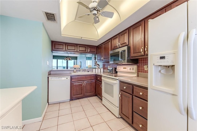 kitchen featuring visible vents, a ceiling fan, white appliances, light countertops, and a sink