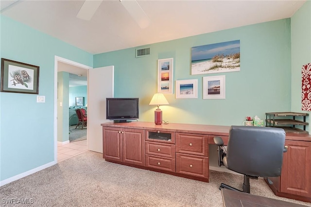 office space featuring visible vents, baseboards, ceiling fan, and light carpet