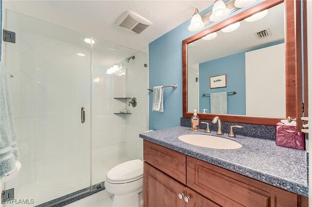 full bathroom with visible vents, a stall shower, toilet, and vanity