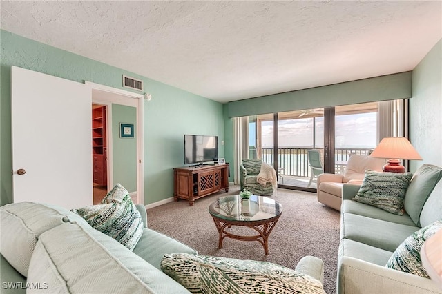carpeted living room with a textured ceiling, visible vents, and baseboards