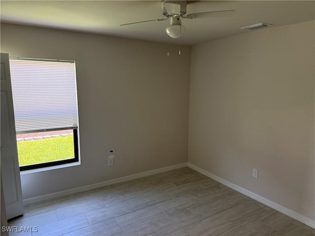 unfurnished room with visible vents, baseboards, ceiling fan, and wood finished floors