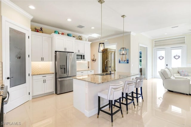 1978 San Marco Rd, Marco Island, FL 34145 - kitchen with appliances with stainless steel finishes, a sink, crown molding, backsplash, and light stone countertops