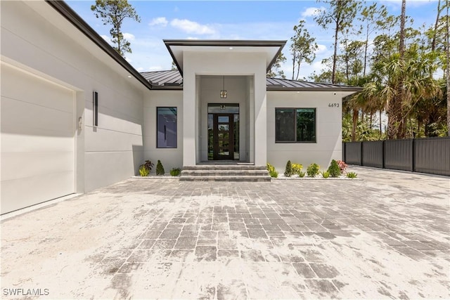 4693 13th Ave SW, Naples, FL 34116 - entrance to property with stucco siding, fence, metal roof, and a standing seam roof