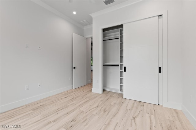 4693 13th Ave SW, Naples, FL 34116 - unfurnished bedroom featuring a closet, baseboards, visible vents, crown molding, and wood finished floors
