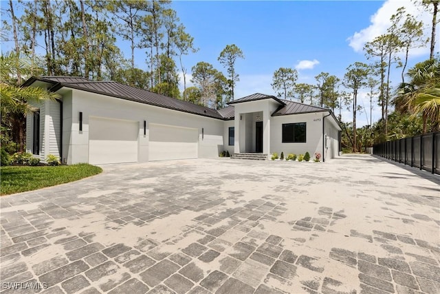 4693 13th Ave SW, Naples, FL 34116 - view of front of home with a standing seam roof, fence, decorative driveway, metal roof, and an attached garage